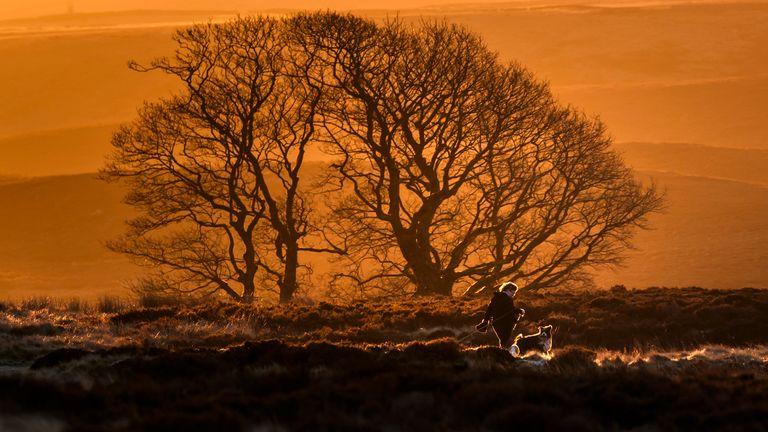 A woman walking her dog on the Pennine tops near Haworth, West Yorkshire, on Hogmanay. Pic: PA