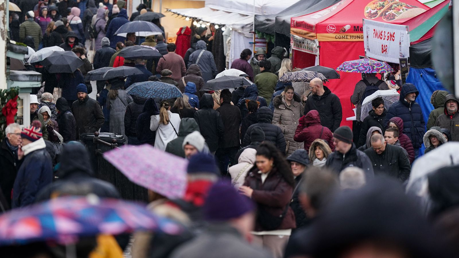 People in Stratford-upon-Avon during wet weather on Sunday. Pic: PA