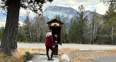 Valerie Fortney admires the phone at Banff's Tunnel Mountain campground, Mount Rundle in the background, Alta.