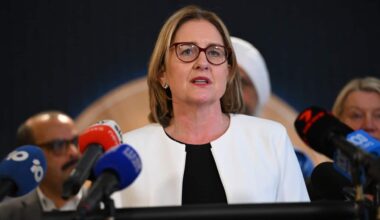 Premier Jacinta Allan speaks from podium to an array of media microphones