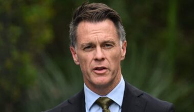 A white middle-aged man with brown and grey hair wearing a suit and speaking outside.