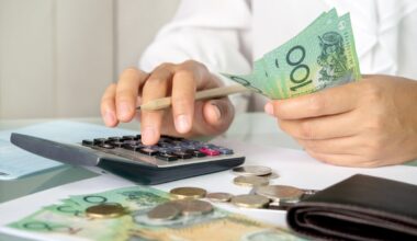 A person using a calculator while holding money in hand to count.