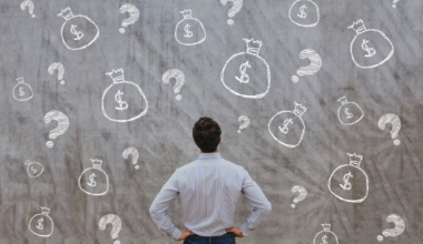 A person looks at a wall with floating money bags and question marks.