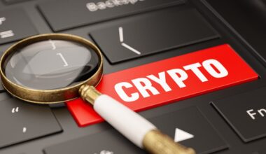 A spyglass resting on a computer keyboard equipped with a red Crypto button.