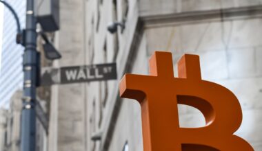 A Bitcoin logo in front a Wall Street sign.