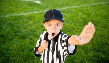 A child in a referee uniform putting their hand up to say stop.