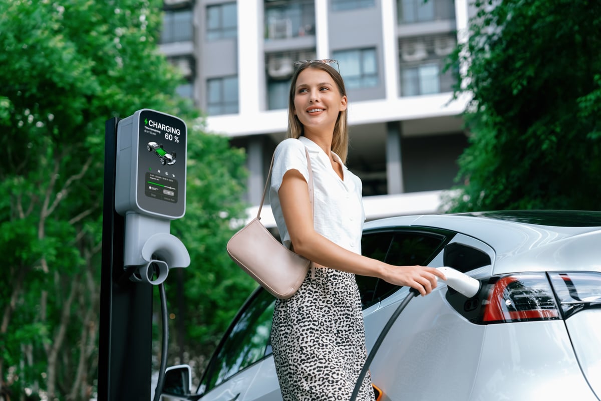 A woman charges her electric car.
