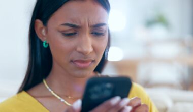 Person looking at phone with confused look.