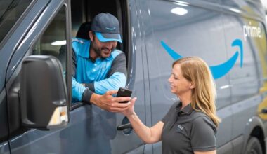 An Amazon driver checks a delivery on a smartphone.