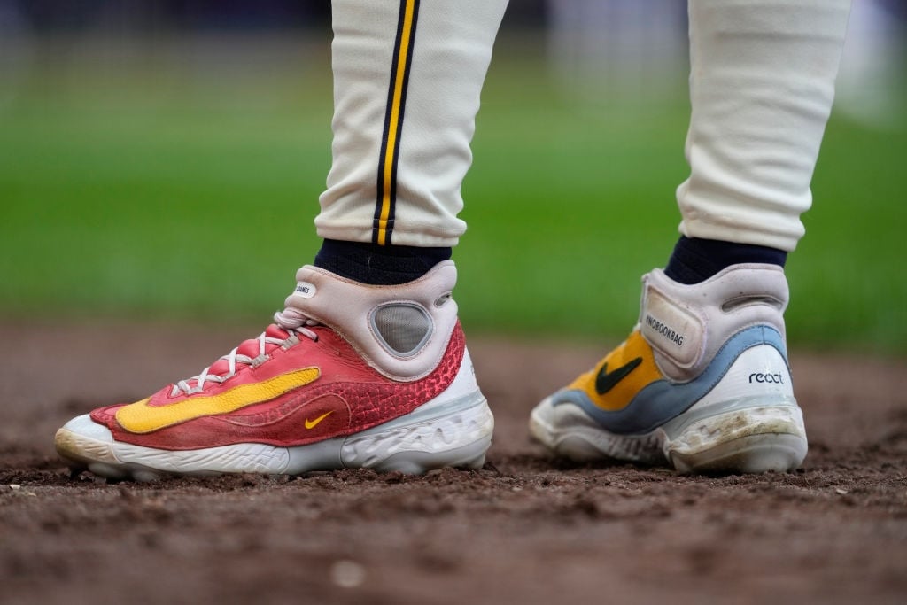 Baseball player wearing two different Nike shoes, standing in the infield.