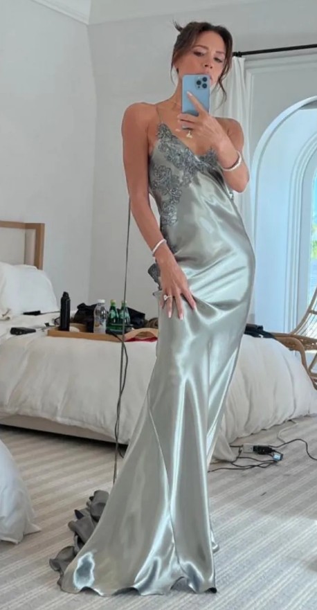 Victoria Beckham taking a selfie in a light green silky gown with lace detail.