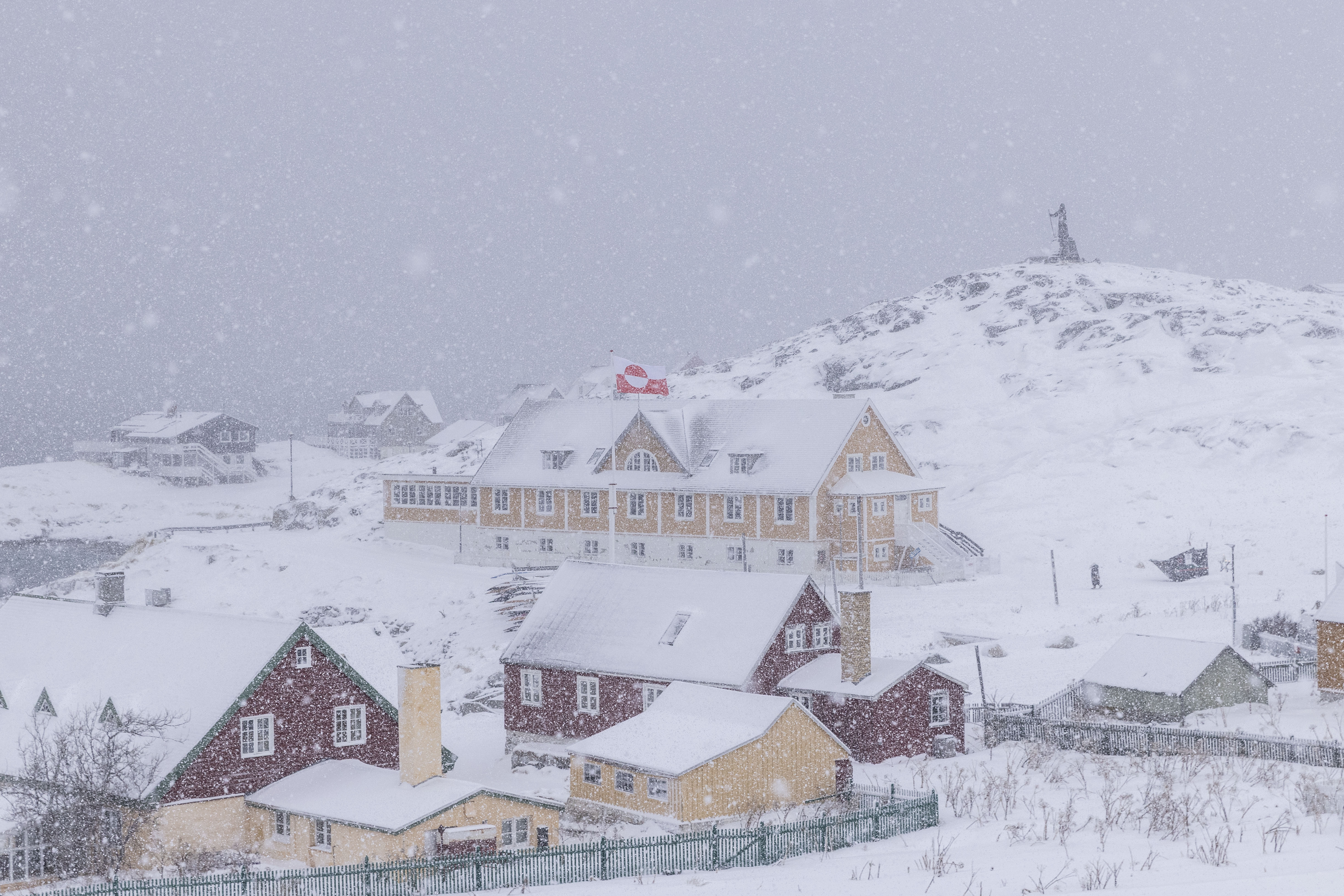 Snow falling over buildings in Nuuk, Greenland.