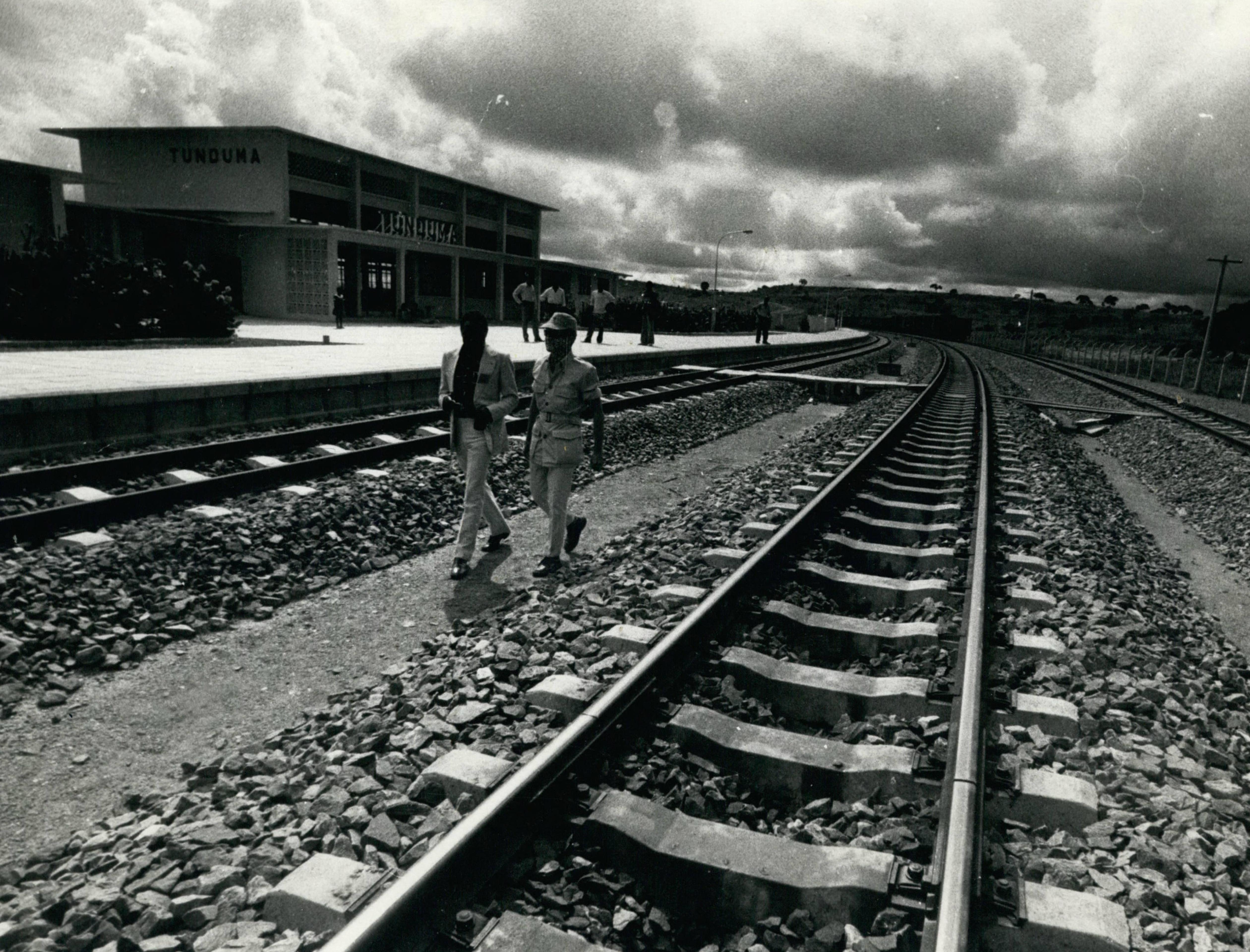 International travel writer Charles E. Adelsen inspects the tracks of the Uhuru Railway at the Tunduma border station in Tanzania.