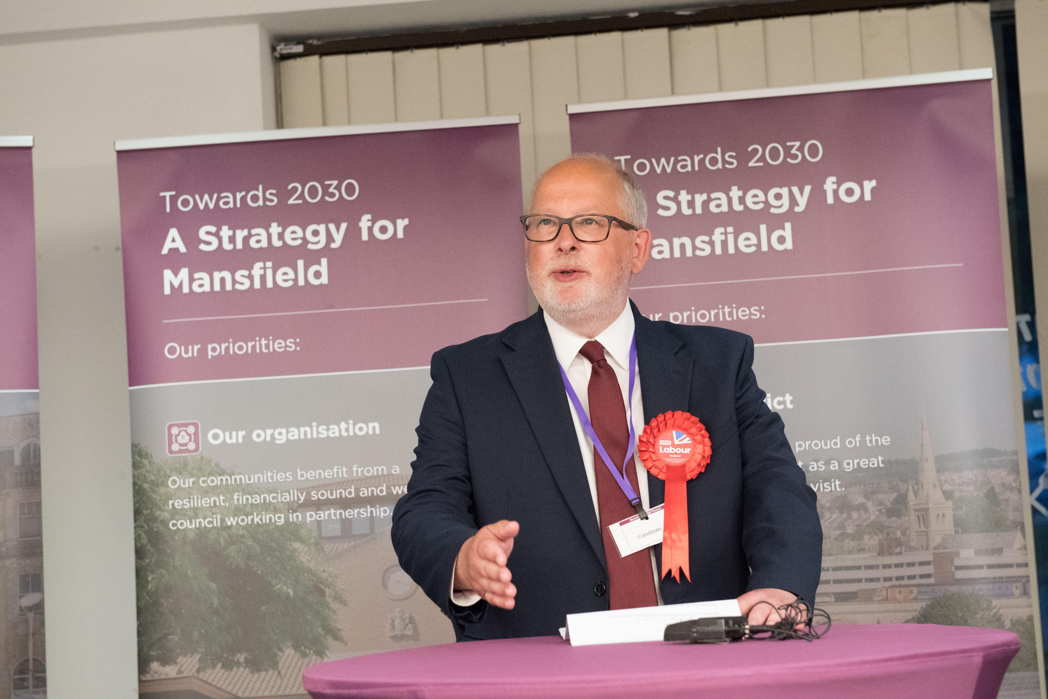 Steve Yemm of the Labour Party at a podium in front of "Towards 2030 A Strategy for Mansfield" banners.