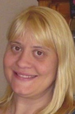 Headshot of Dawn Rhodes, a woman with long blonde hair and bangs, smiling faintly.