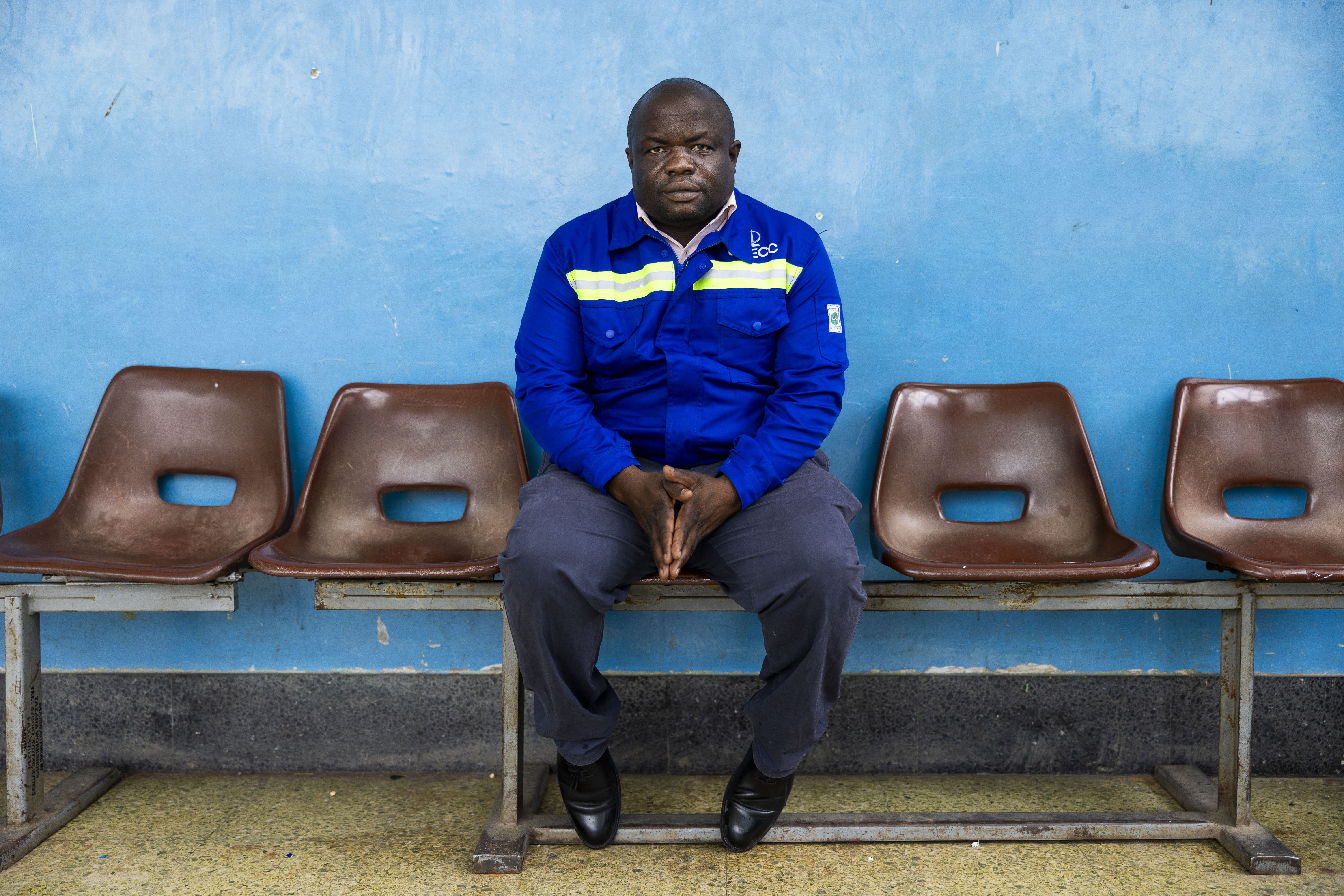 Hezekiah Musonda, 43, Regional Mechanical Engineer for Tazara rail line, sitting on a waiting room bench.