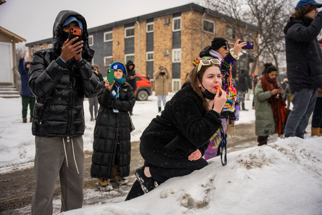 People record on their phones and blow whistles as federal agents make arrests in Minneapolis on January 21.