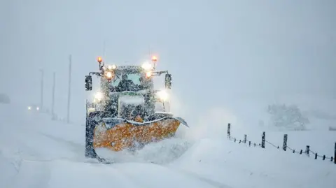Getty Images A snowplough clearing a route on a snow-covered road.