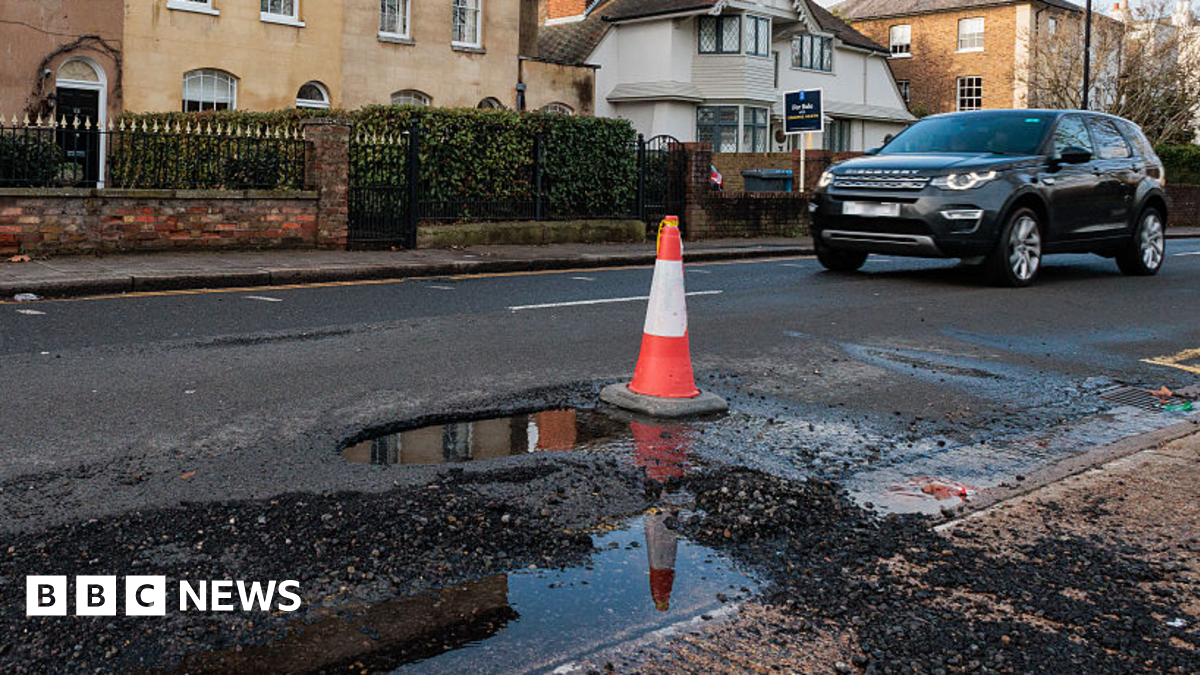 A car approaches a pothole marked with a traffic cone in Windsor on 12.1.26.