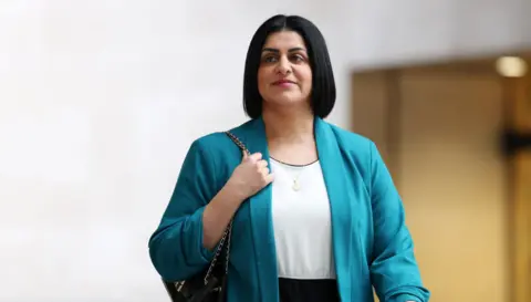 EPA  Home Secretary Shabana Mahmood arrives at the BBC in London. She is wearing a turquoise blazer and has a black handbag wrapped over her right shoulder