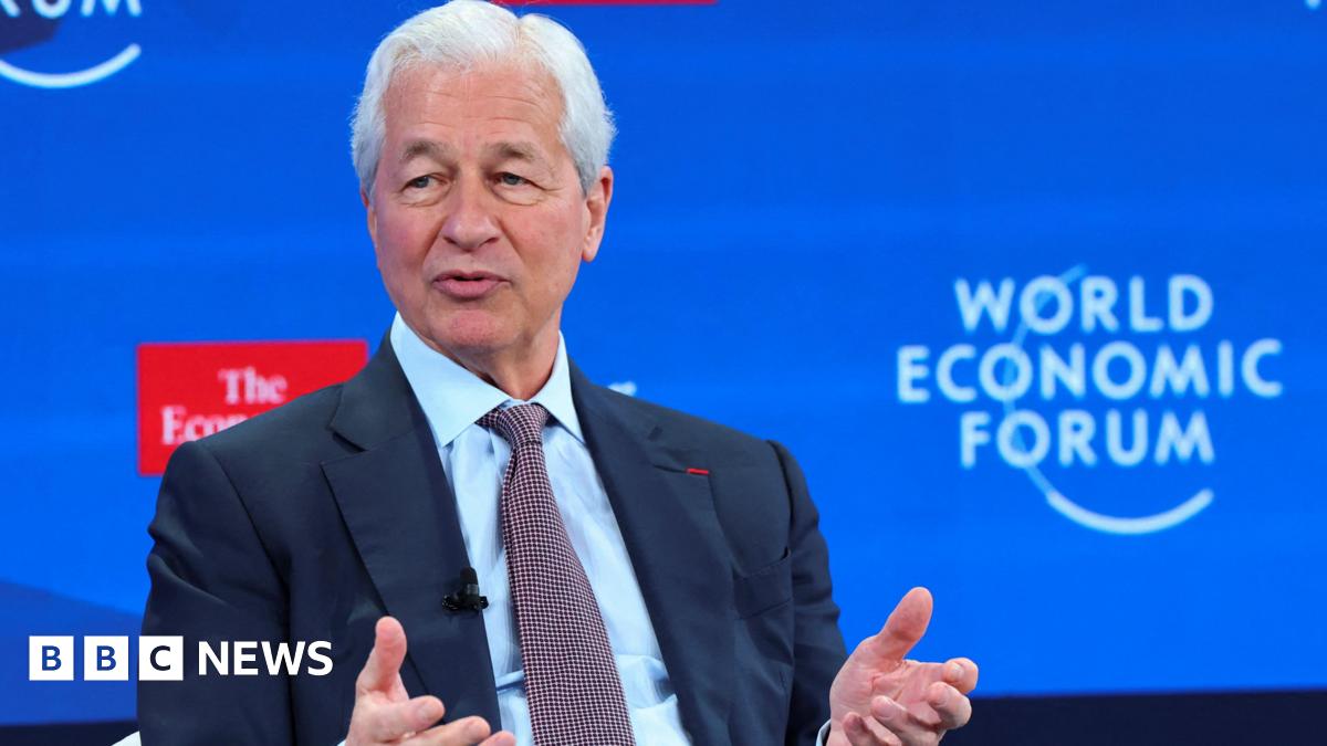 The CEO of JPMorgan Chase, Jamie Dimon, in a navy blue suit speaks in front of a blue World Economic Forum (WEF) backdrop at the conference in Davos, Switzerland, January 21, 2026