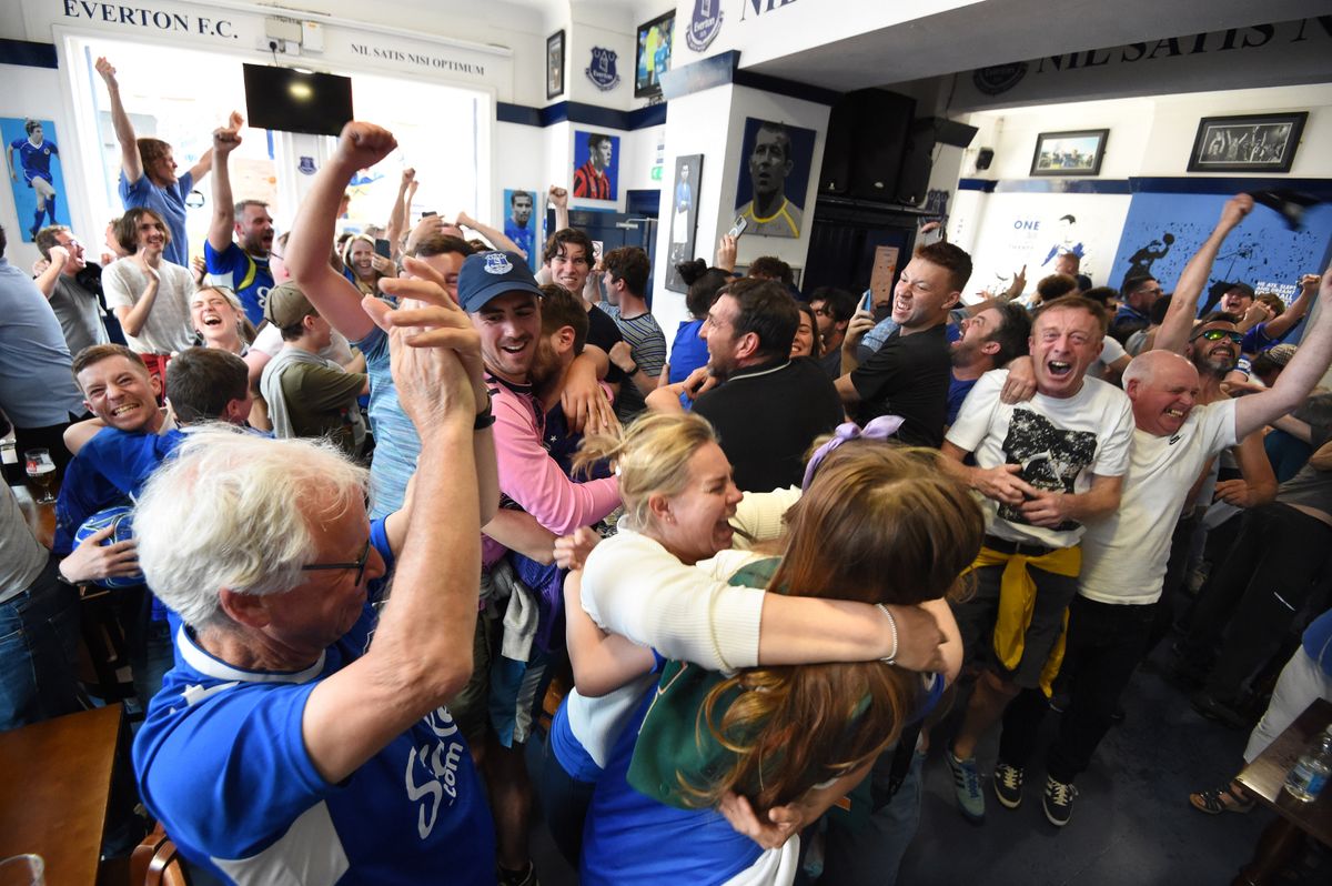 Everton fans celebrate beating Bournemouth and surviving relegation in May 2023 in The Winslow Hotel