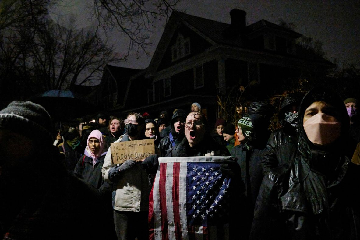 Taylor Chaika holds an American flag while chanting with a crowd of protesters in Minneapolis on January 8.