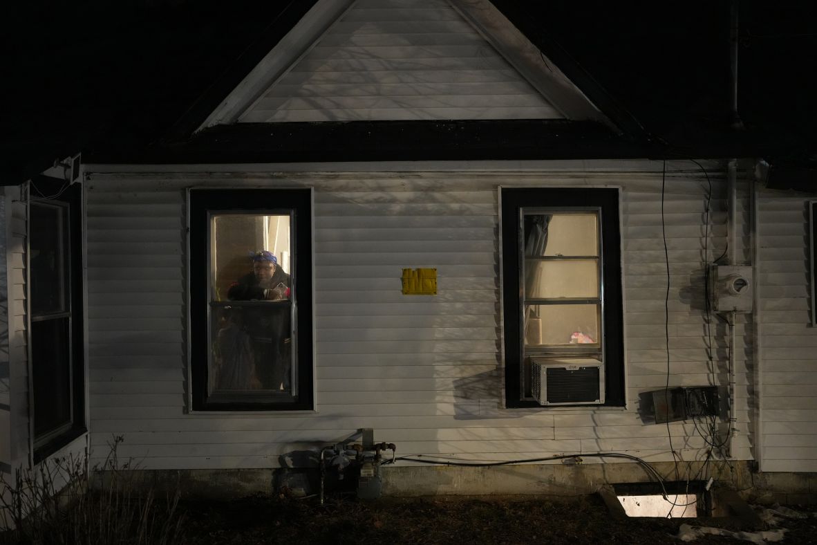 Residents watch from their windows as federal agents sweep through the streets of Minneapolis on January 14.