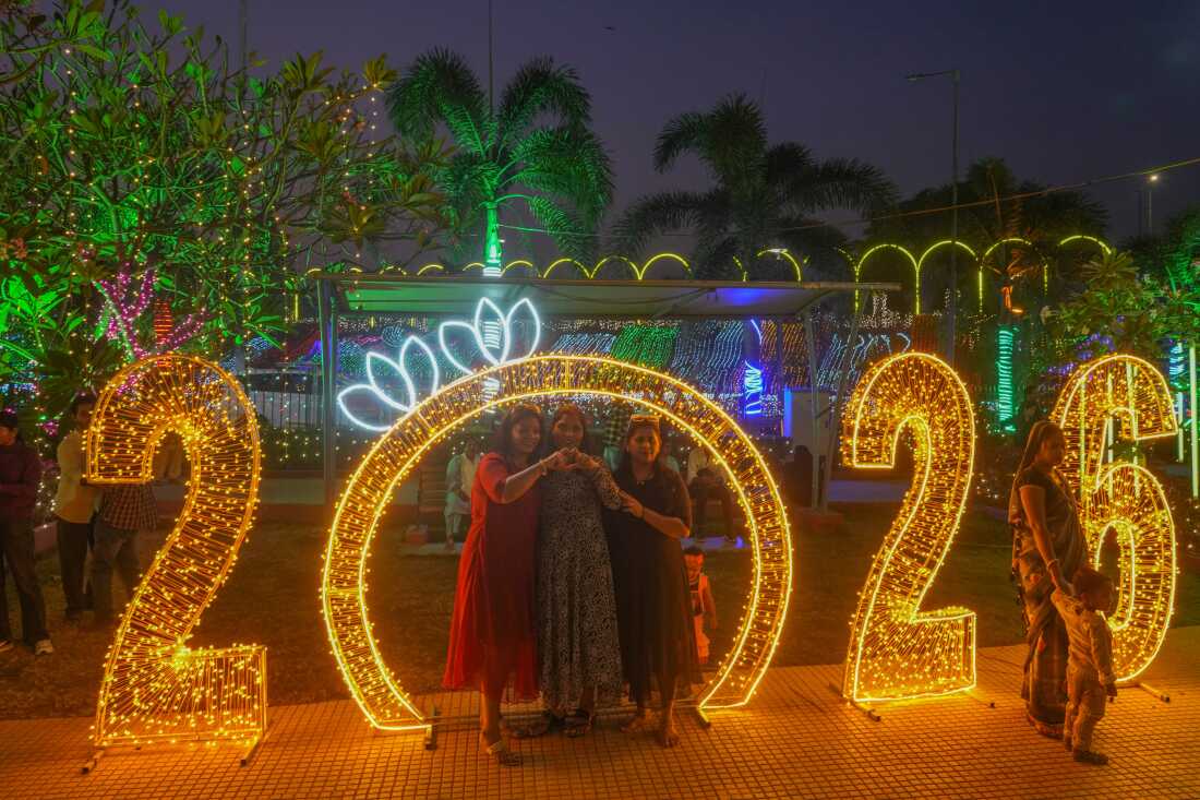 People pose for pictures near illuminated decorations on New Year's Eve in Mumbai, India 