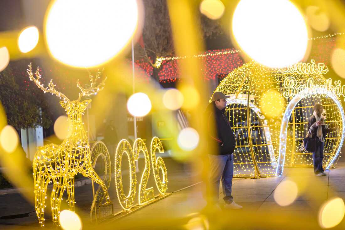 Onlookers stand beside light ornaments on New Year's Eve at Bakrkoy Square in Istanbul  