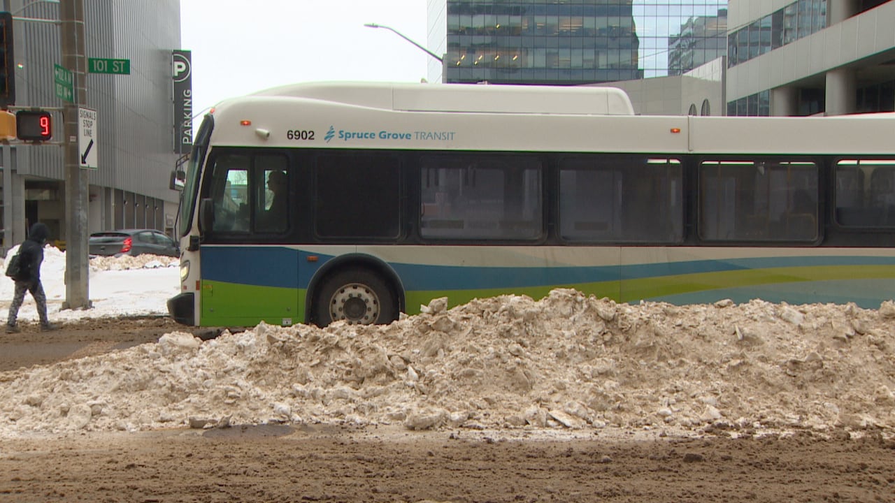 A bus is seen by a pile of snow.