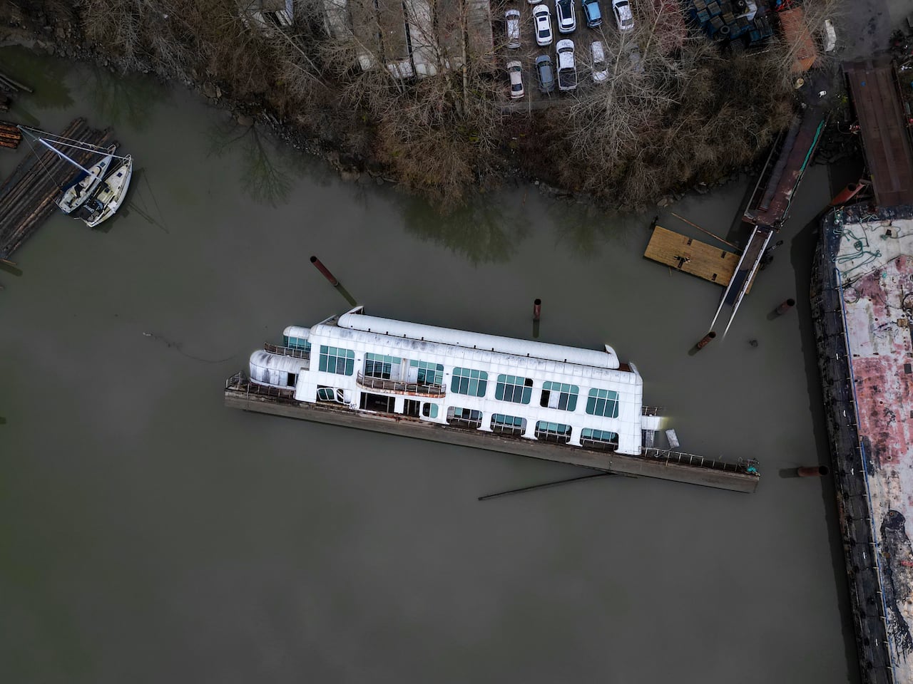 A white barge sits in a river of water on its side.
