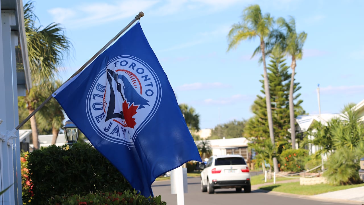 A Toronto Blue Jays flag flies outside a house.