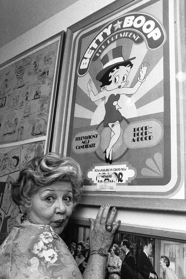 Mae Questel, who provided the loopy, childlike voice of cartoon characters Betty Boop and Olive Oyl, poses in this 1978 file photo with a poster of a version of Betty Boop. (AP Photo/File)