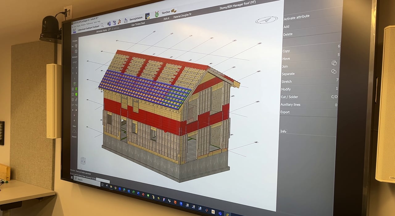 A projector screen displays a 3D digital mock up of a two-story mass timber panel house 