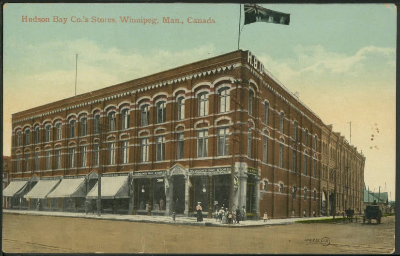 A brown brick three-storey building with awnings on the street level