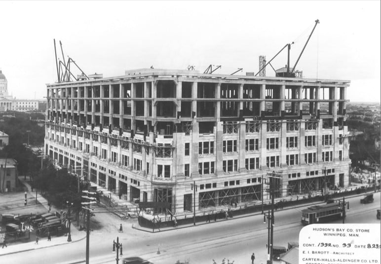 Black and white photo of a large building under construction.