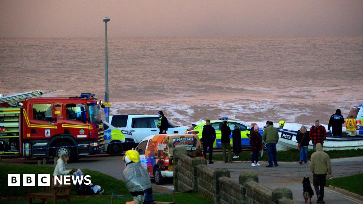 Shot of a fire engine, police car and emergency workers on the seafront in Withernsea.