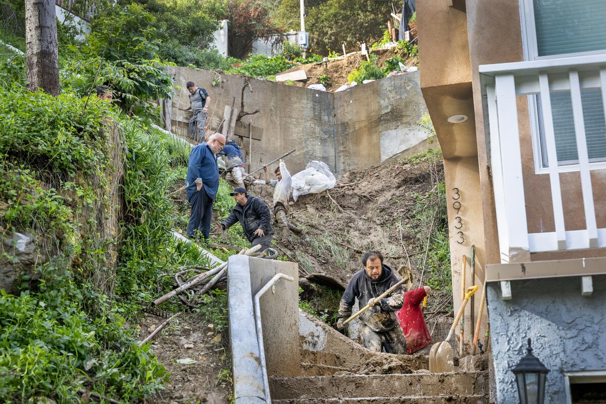 Crews work to clear a mud and debris flow
