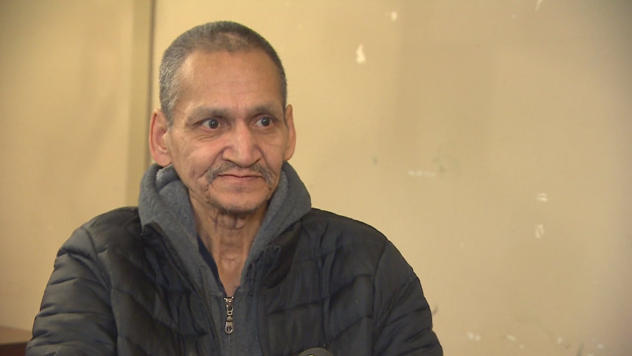 Man with grey hair and grey moustache wears a dark puffer jacket