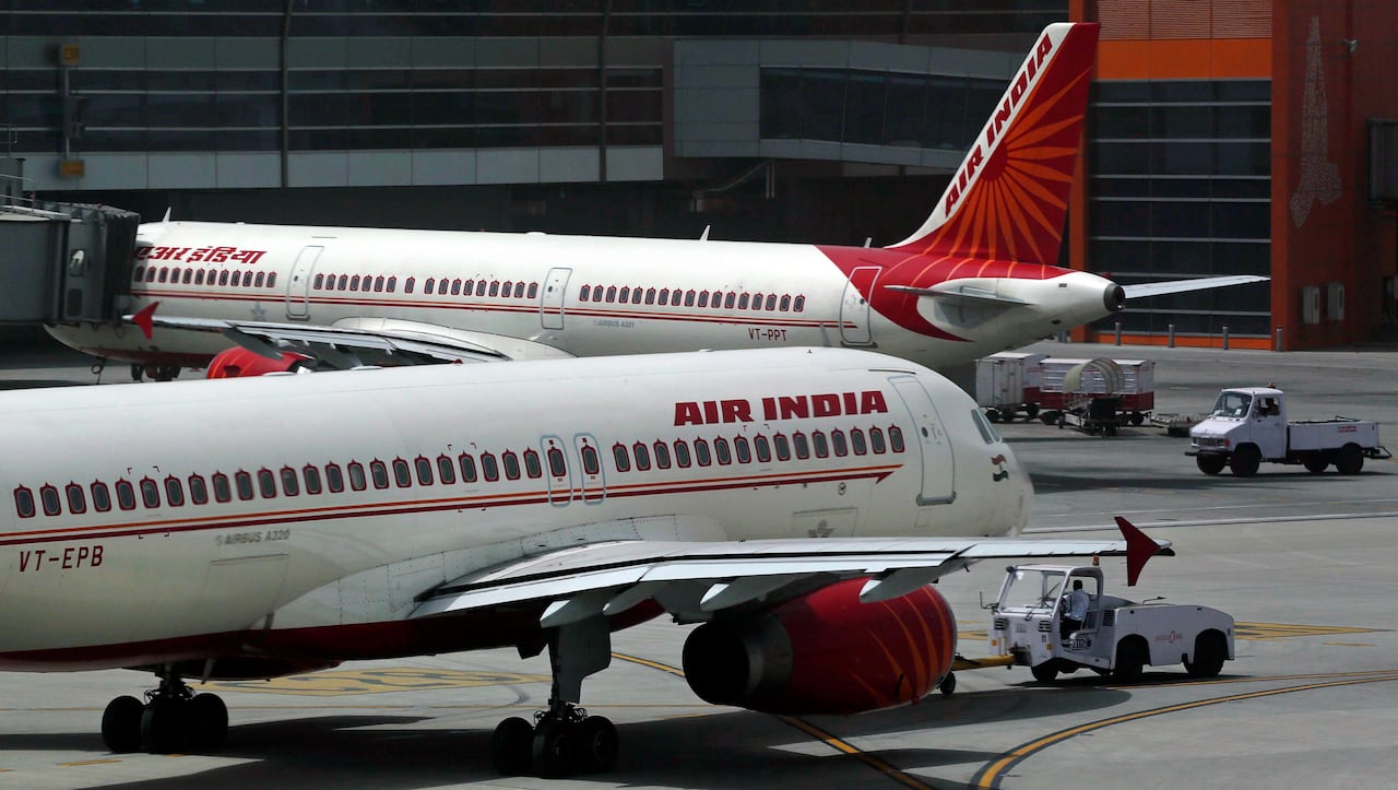 Two planes with red detailing are seen on the tarmac.