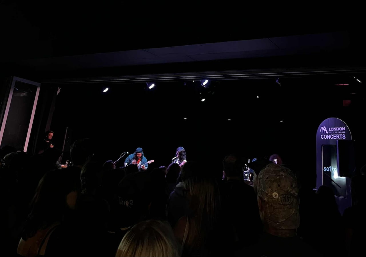 A crowd watches a band on stage at night