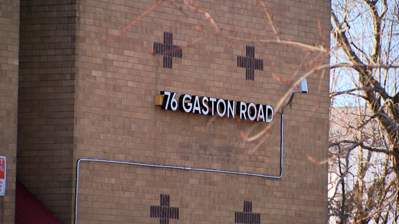 A brick facade of a building with the address marker.