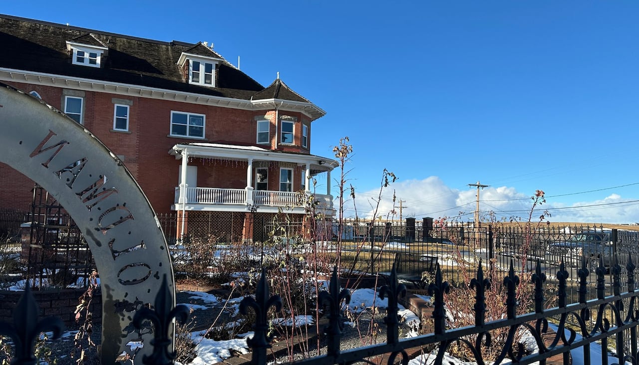 A rose garden beside a historic red brick building.