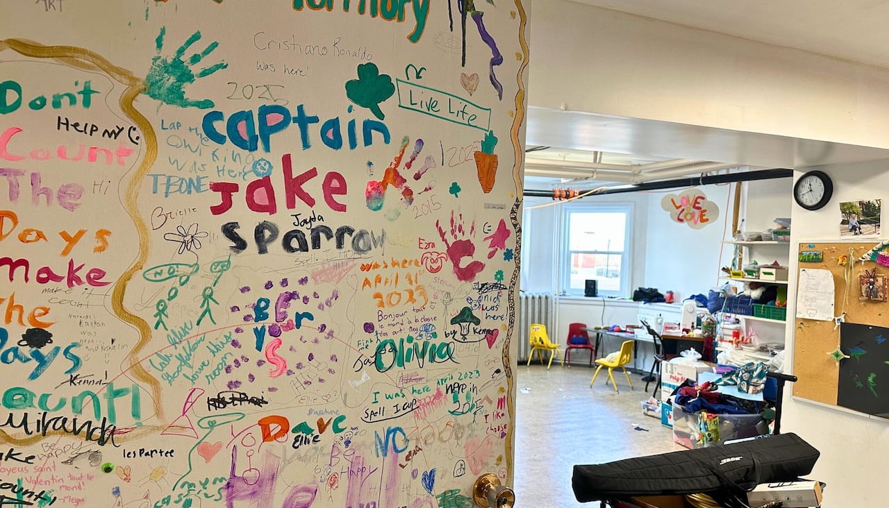 A door is covered with notes and hand prints.