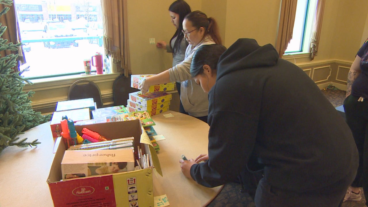 A group of people line up objects on a table. 