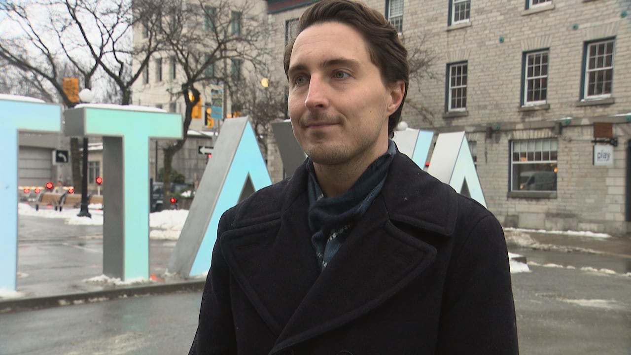 Man standing in front of Ottawa sign.