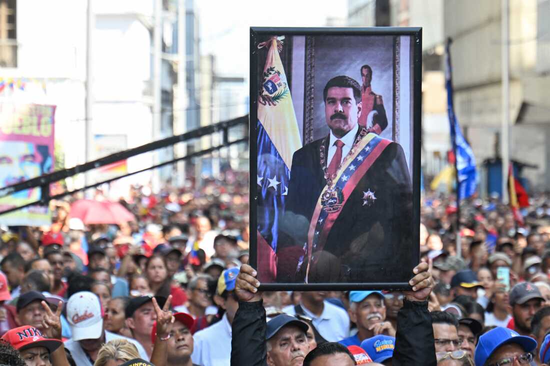 A supporter of ousted Venezuela's President Nicolas Maduro carry his portrait during a rally outside the National Assembly in Caracas on Jan. 5, 2026.