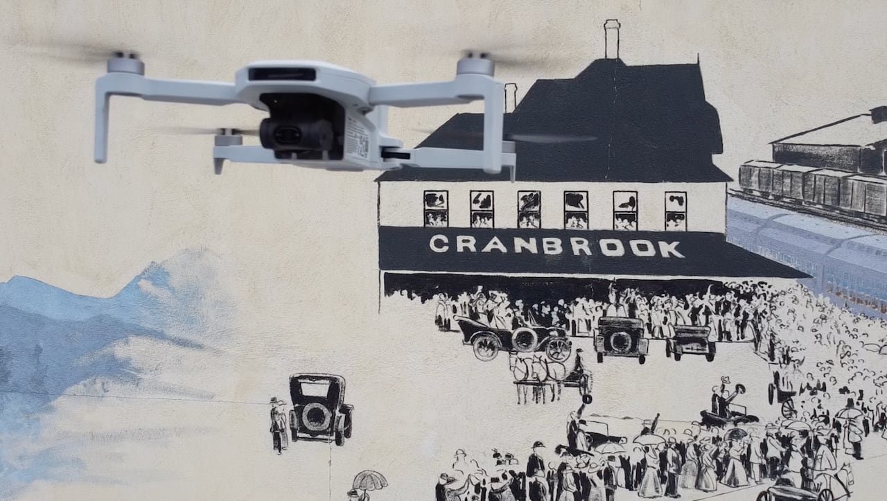 A drone flies near a drawing of a building and the words 'Cranbrook' on it.