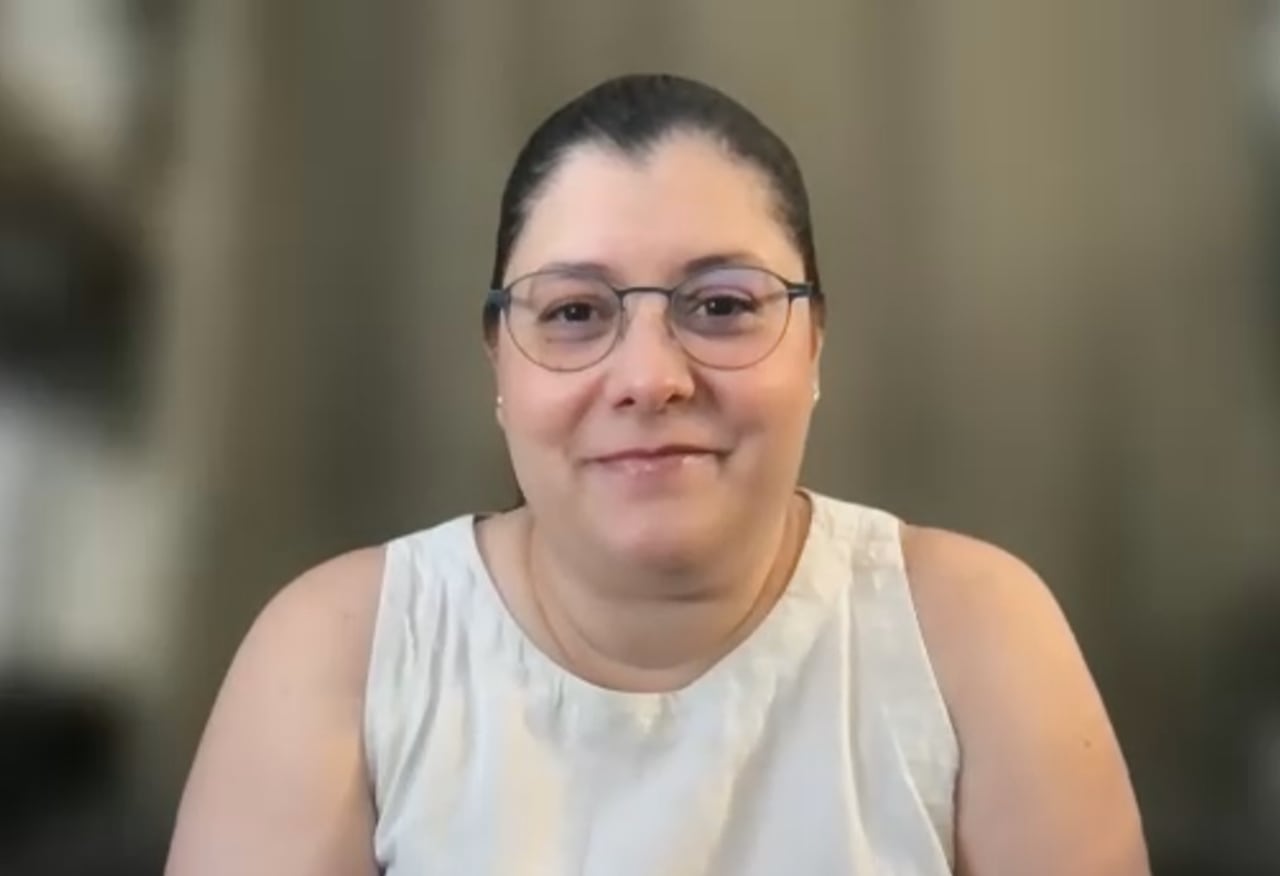 A woman in glasses during a zoom call.